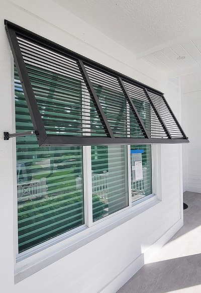 Our products: Bahama Shutters Blue Bahama shutters custom-installed on a coastal home in Naples – Shutter Specialists